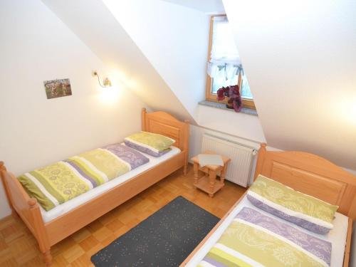 a small bedroom with two beds and a window at Ferienhaus mit Wellnessbereich in Schönsee