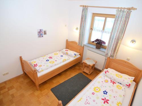a small bedroom with two beds and a window at Cozy group house with its own garden and wellness area in Schönsee