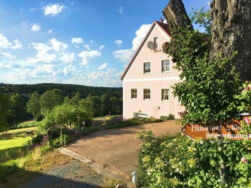 a white house with a sign in front of a driveway at Ferienhaus mit Wellnessbereich in Schönsee