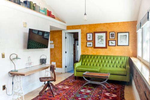 a living room with a green couch and a table at Argos Inn - Ithaca's Boutique Hotel in Ithaca