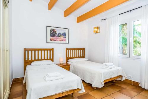 two beds in a room with white walls at Diane in Binibeca