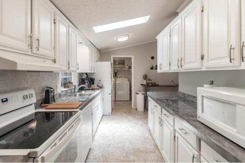 a kitchen with white cabinets and marble counter tops at Twin Ponds Retreats retreat in Whittier