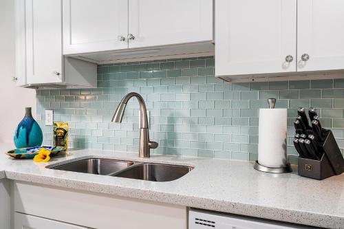a kitchen counter with a sink and blue tiles at Oceanfront Luxury Condo in Kailua-Kona