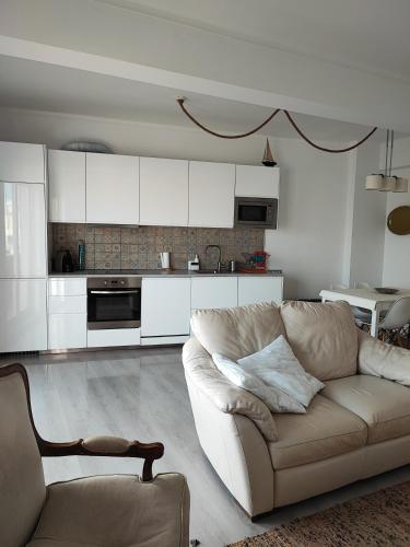 a living room with a couch and a kitchen at Milu house in Faro
