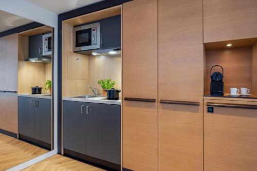 a kitchen with wooden cabinets and a sink at The Westin Grand Berlin in Berlin