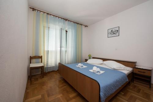 1 dormitorio con 1 cama con manta azul en Apartment Brela 16603b en Brela