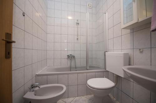 a bathroom with a toilet and a sink and a tub at Apartment Brela 16603b in Brela