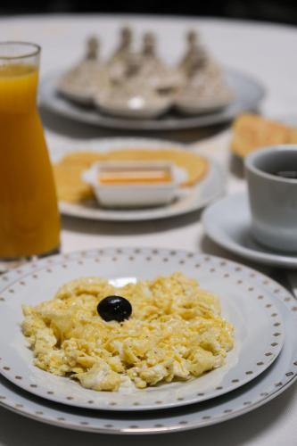 a plate of scrambled eggs with a black olive on it at Le Grand Alcazar - Riad in Fès