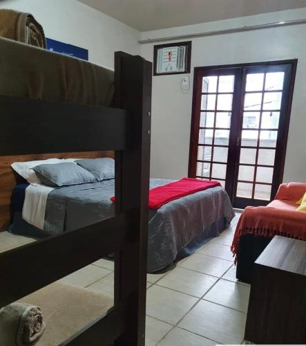 a bedroom with two bunk beds and a window at Pousada Praia do Recreio in Rio de Janeiro