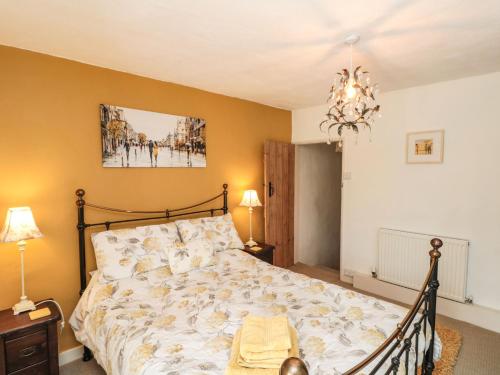 a bedroom with a bed and a chandelier at 12 Castlegate in Pickering