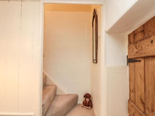 a teddy bear sitting on the floor next to a door at 12 Castlegate in Pickering