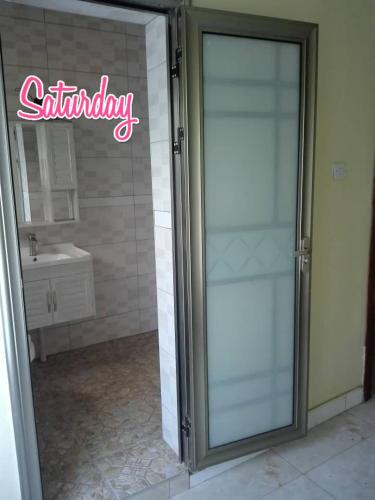 una puerta de ducha de cristal en un baño con lavabo en Matalente Abode en Lilongüe