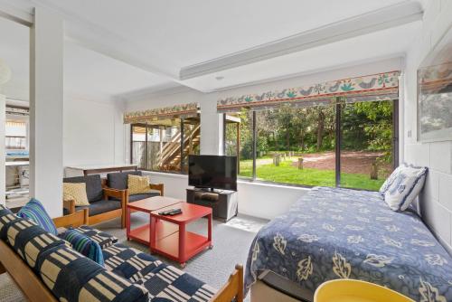 a living room with a bed and a couch at Surfside on Mollymook Beach in Mollymook