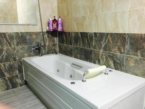 a bathroom with a bath tub and a sink at Pearl Business Hotel in Gumi