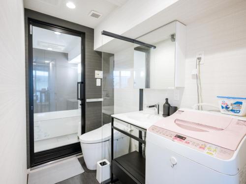 Baño blanco con lavabo y aseo en Sukumo -蒅-, en Tokio