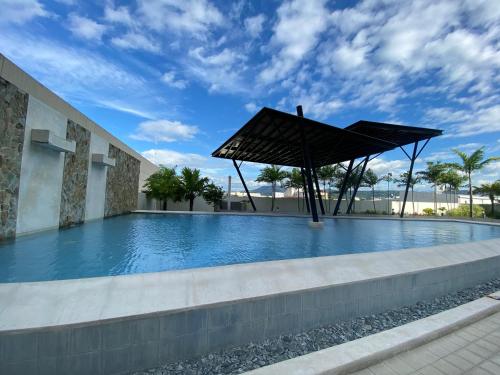 a swimming pool with a large umbrella in a building at Simple Studio Unit N Centrio Tower in Cagayan de Oro