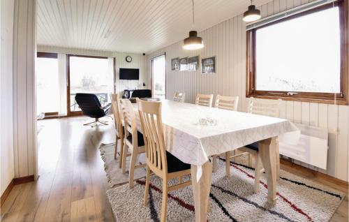 a dining room with a white table and chairs at Four-Bedroom Holiday Home In Brenderup Fyn in Skovs-Højrup
