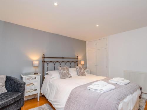 a bedroom with a bed and a chair with towels on it at Mermaid Cottage in Whitby
