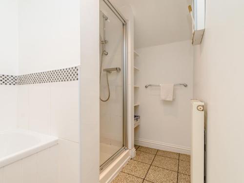 a bathroom with a shower with a glass door at Mermaid Cottage in Whitby