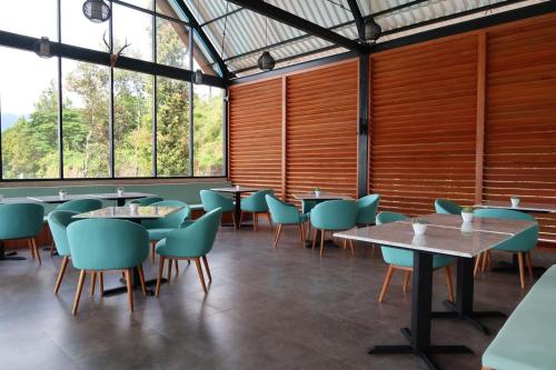 a dining room with tables and chairs and windows at Rusa by The Lake in Baturiti