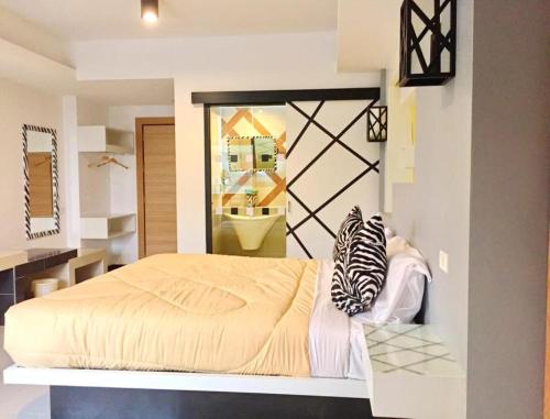 a bedroom with a bed in a room with a mirror at Win Hotel Phayao in Phayao