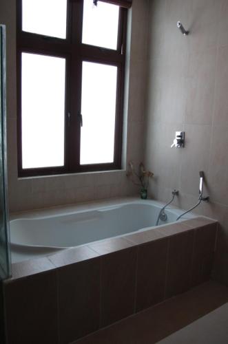 a bath tub in a bathroom with a window at Penang Batu Ferringhi Beach Bungalow Villa in Batu Ferringhi