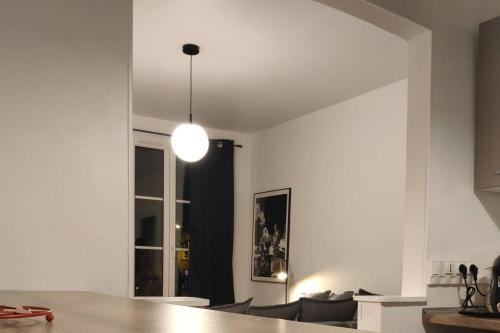 a living room with a table and a light fixture at Au cœur du Quartier St Vincent de Paul, Le Havre in Le Havre