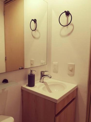 a bathroom with a sink and a mirror at Moderno, ubicación estratégica. in Bucaramanga