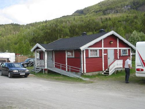 a red house with a man standing in front of it at Nordnes Kro og Camping in Rokland