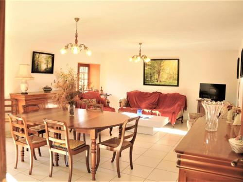 - un salon avec une table et des chaises en bois dans l'établissement Stone house with private pool, à Villefranche-du-Périgord
