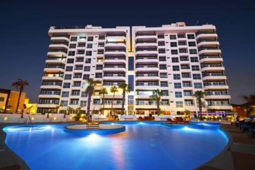 a large white building with a pool in front of it at Condo en Torres Cantera de 2 recámaras 2 1/2 baños in La Paz
