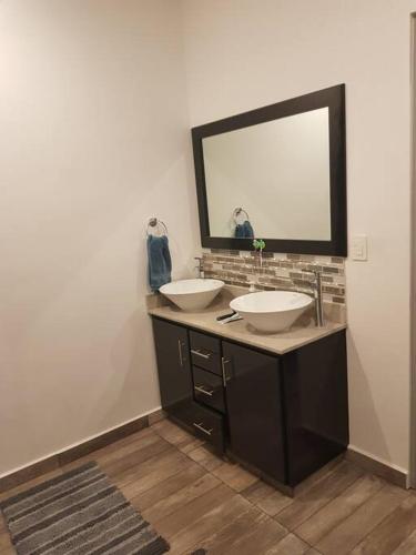 a bathroom with two sinks and a large mirror at Condo en Torres Cantera de 2 recámaras 2 1/2 baños in La Paz