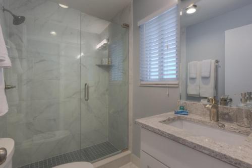 a bathroom with a shower and a sink and a toilet at Good Times Tan Lines Oceanview Condo Pet Friendly in Jacksonville Beach