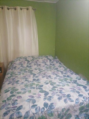 a bedroom with a bed with a floral comforter at Casa Juliana in El Aibal