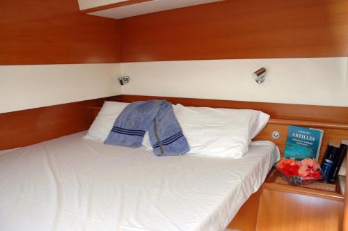 a bedroom with a bed with a jacket on it at Catamaran TAO in Sainte-Anne
