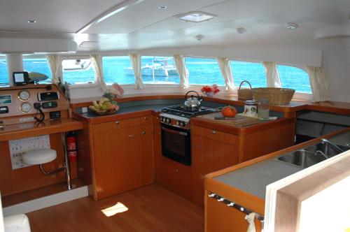 a kitchen with wooden cabinets and a stove in a boat at Catamaran TAO in Sainte-Anne