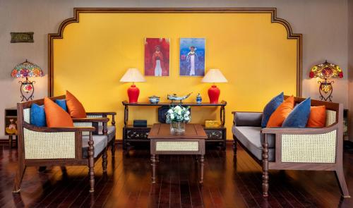 a living room with two couches and a yellow wall at Indochine Cruise Lan Ha Bay in Ha Long