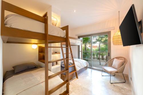 a bedroom with bunk beds with a desk and a chair at La Amada Cancun in Cancún