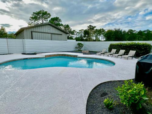 a small swimming pool with chairs in a yard at Beautiful Beach house with heated pool in Jacksonville