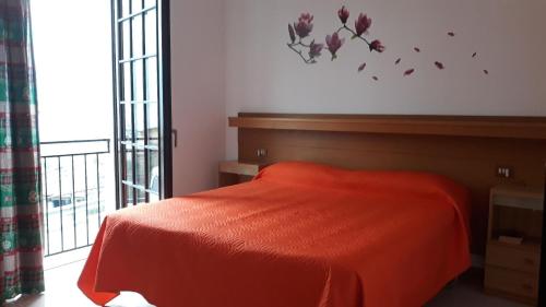een slaapkamer met een bed met een rode deken en een raam bij Appartement in Cassone Di Malcesine mit Garten in Malcesine