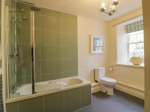 a bathroom with a shower and a tub and a toilet at Port Donnel Cottage in Dalbeattie