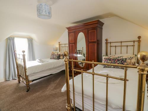 um quarto com 2 camas e um espelho grande em Port Donnel Cottage em Dalbeattie