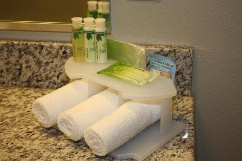 a bathroom sink with towels and toiletries on a counter at Fairfield by Marriott Inn & Suites Fort Walton Beach Hurlburt Area in Fort Walton Beach