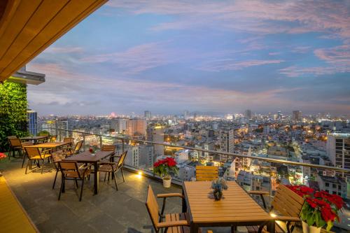 a balcony with tables and chairs and a city skyline at Diamond Sea Hotel in Da Nang