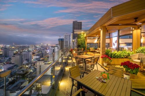 a balcony with tables and chairs and a city skyline at Diamond Sea Hotel in Da Nang