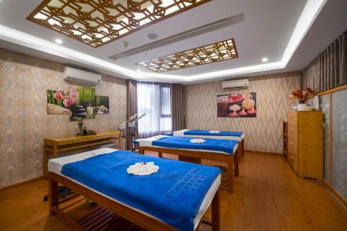 two beds in a hospital room with blue sheets at Diamond Sea Hotel in Da Nang