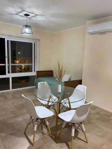 a dining room with a glass table and white chairs at Edificio Giu 3 in San Salvador de Jujuy