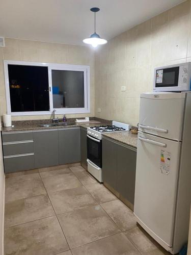 a kitchen with a white refrigerator and a stove at Edificio Giu 3 in San Salvador de Jujuy