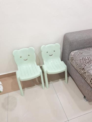 two white chairs sitting next to a bed at Air-home M9 Simpang near Aulong Econsave, 4BR, 10pax, Netflix in Taiping