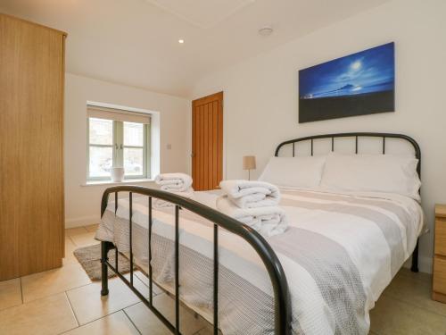 een slaapkamer met een bed met handdoeken erop bij Pen Tewan in Penzance